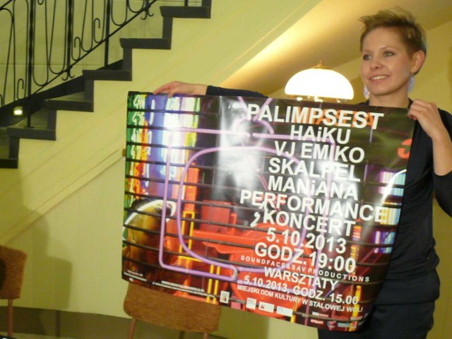 Magdalena Bąk prezentuje plakat koncertu wrocławskich i krakowskich artystów.