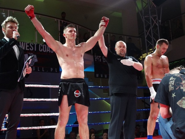 Mateusz Hiki z uniesionymi rękoma po zwycięskiej walce o tytuł zawodowego mistrza Polski w K-1.