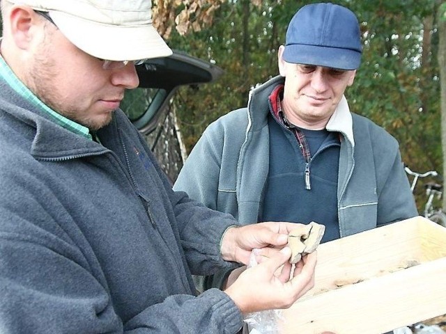 Dominik Płaza (z lewej) i dr Piotr Papiernik oglądają znaleziska. Na zdjęciu fragment zdobionego naczynia 