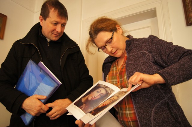 Anna Borowska ( z prawej) pokazuje na zdjęciach ks. Piotrowi Mamakowi uszkodzenia i ubytki w obrazie, które wykazały badania