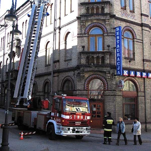 Stan techniczny nie remontowanego od lat Domu Narodowego jest fatalny. Nz. strażacy oczyszczają ulicę po tym, jak do ścian budynku odpadły kawałki gzymsu. Skończyło się jedynie na uszkodzeniach samochodów.