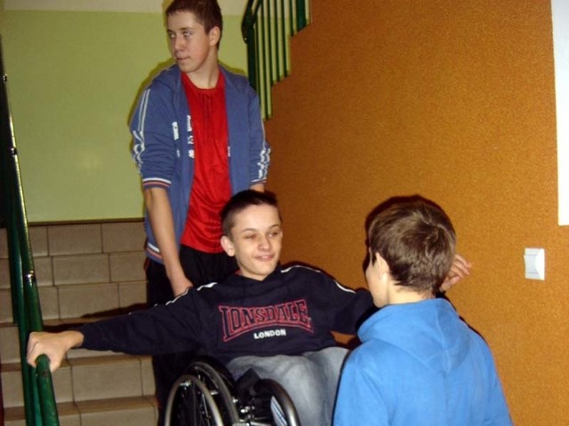 W Zespole Szkół w Płonce Kościelnej nie ma windy, więc Damian Śliwowski i Konrad Płoński wnoszą wózek z niepełnosprawnym Marcinem Łupińskim po schodach