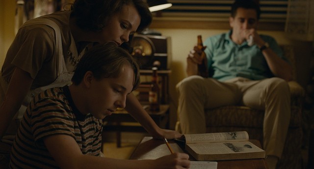 Carey Mulligan, Jake Gyllenhaal (w tle) i Ed Oxenbould nad pracą domową. Pozornie szczęśliwa rodzina na chwilę przed kryzysem. Kadr z filmu Wildlife, czyli Kraina wielkiego nieba