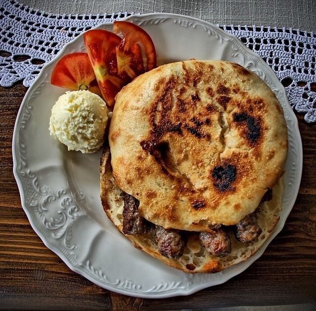 Serbskie ćevapi podajemy w chlebku pita albo podpieczonej bułce. Dodatkiem może być sałatka pomidorowa.