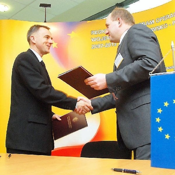 Burmistrz Waldemar Stupałkowski i Piotr  Całbecki podpisują umowę na molo, halę i  ścieżkę