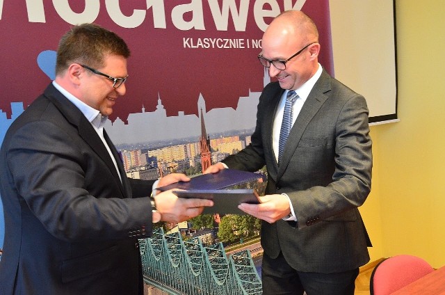 Porozumienie podpisane. Jacek Kowalski, członek zarządu Orange Polska i Marek Wojtkowski, prezydent Włocławka wymieniają się dokumentami.