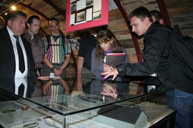 Łukasz Socha (po prawej) w bunkrze-muzeum Stowarzyszenia "Skarb" pokazuje Christine Cohn mapę fabryki benzyny syntetycznej tłumacząc, gdzie podczas nalotów spadły na zakład bomby i jakich dokonały zniszczeń. 