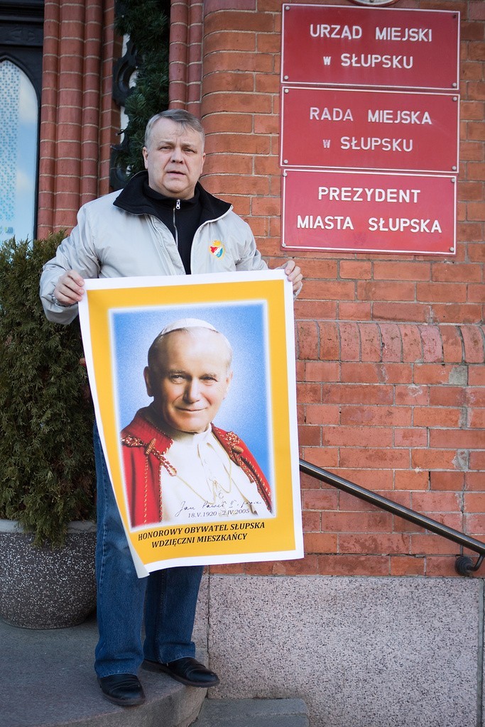 Adam Jaworski wiesza wizerunek Jana Pawła II na drzwiach ratusza w Słupsku