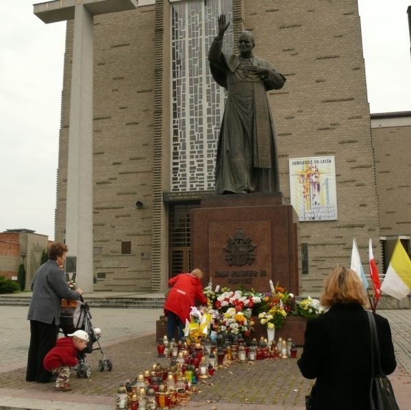 Pod pomnikiem papieża przy bazylice konkatedralnej w Stalowej Woli w czwartek wierni zapalali znicze i składali kwiaty.