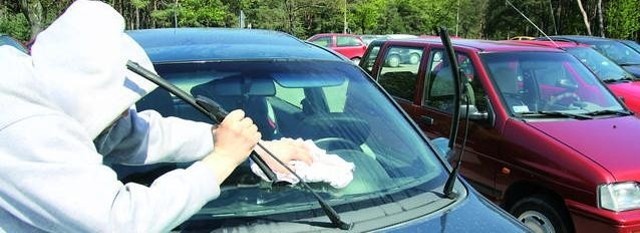 Brudna szmata i bluza z kapturem to znak rozpoznawczy "przedsiębiorców" myjących auta na parkingach