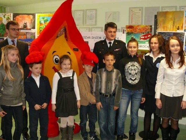 Nagrodzeni uczniowie w konkursie plastycznym ze starostą Robertem Filą i zastępcą komendanta straży pożarnej Jerzym Lipko.