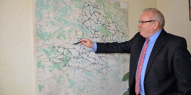 Marek Grad prezentuje mapę, na której na czarno zaznaczone są wyremontowane drogi.