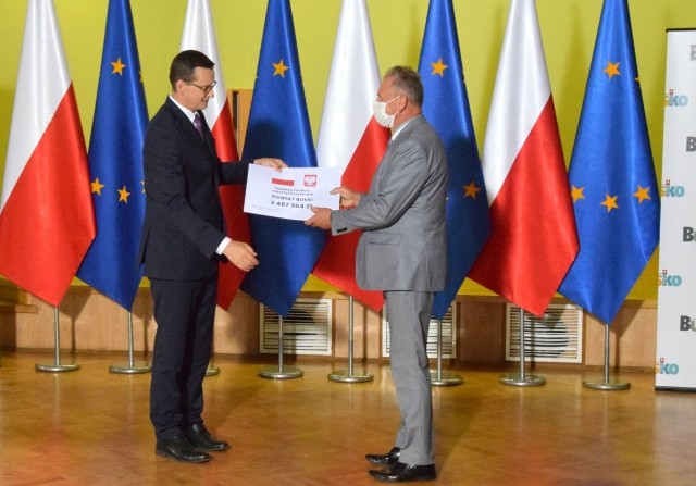Starosta buski Jerzy Kolarz odbiera czek od premiera. Na kolejnych zdjęciach burmistrzowie i wójtowie naszych gmin