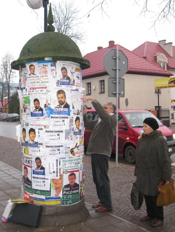 Słup ogłoszeniowy w centrum miasta cały jest zalepiony plakatmi wyborczymi. A nowych wciąż przybywa.