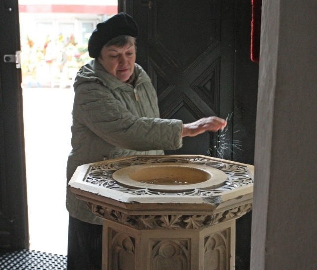 Pani Teresa przy kropielnicy w kościele Mariackim w Słupsku. Pomysły niektórych inspektorów sanepidu uważa za śmieszne.