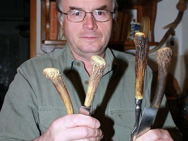 Andrzej Luks prezentuje kuchenne narzędzia oprawione w rogowe rękojeści.