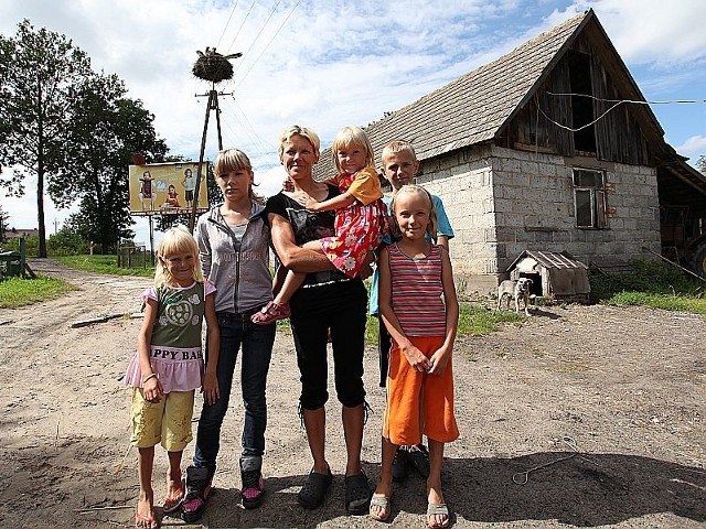 Joanna z najmłodszą Paulinką na rękach. Stoją od lewej: Wiktoria, Sylwia, Sebastian i Julia. Za nimi szopa, która wkrótce stanie się wymarzonym domem.