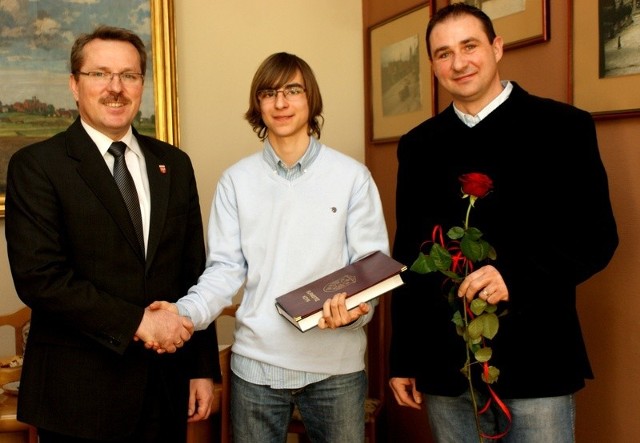 Gratulacje od burmistrza odbiera Mikołaj Tubiszewski, obok z różą - jego ojciec Maciej