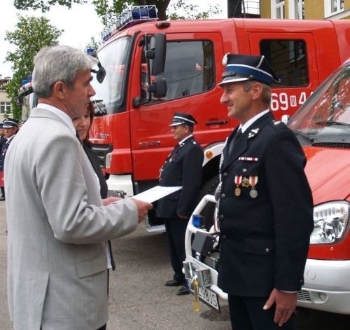 Akt nadania samochodu gaśniczego dla jednostki ochotniczej straży pożarnej wręcza wójt Magnuszewa Henryk Plak (z lewej).