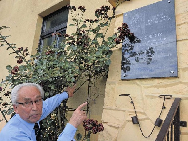 Edward Wójcik wskazuje na tablicę upamiętniającą budowę szkoły (lata 1910-1912)