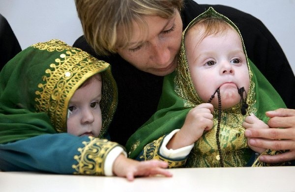 Wyraźnie zadowolone i uśmiechnięte  wróciły we wtorek do Polski i rodzinnego  Janikowa 17-miesięczne syjamskie  bliźniaczki Daria i Olga, które 3 stycznia  przeszły operację rozdzielenia w  Rijadzie. Dziewczynki - na zdjęciu z  mamą Wiesławą Dąbrowską - wróciły do  kraju ubrane w tradycyjne arabskie,  zielone stroje, ze złotym ornamentem.  Przed wyjazdem z Arabii podarowała je  jedna z saudyjskich gazet. Na lotnisku na  Darię i Olgę czekał ich ojciec Janusz  Kołacz. Siostry nie są jeszcze całkiem  zdrowe, dalsze leczenie i rehabilitację  będą przechodzić pod nadzorem  Centrum Zdrowia Dziecka w Warszawie.  - Mamy nadzieję, że w przyszłości o  tym, że były złączone, będą im  przypominać tylko zdjęcia, ale dziś nie  wiemy tego na pewno - powiedziała na  konferencji prasowej na lotnisku Okęcie  Jolanta Jeżewska, lekarka z Bydgoszczy,  która towarzyszyła dziewczynkom w  Arabii Saudyjskiej. Konferencję otworzył  ambasador Królestwa Arabii Saudyjskiej  w Polsce Osamah Al-Sanosi.