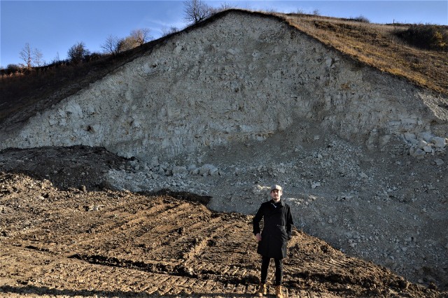 Bartłomiej Małczyński na tle skarpy w Chodowie, z której pobrano materiał do budowy dróg