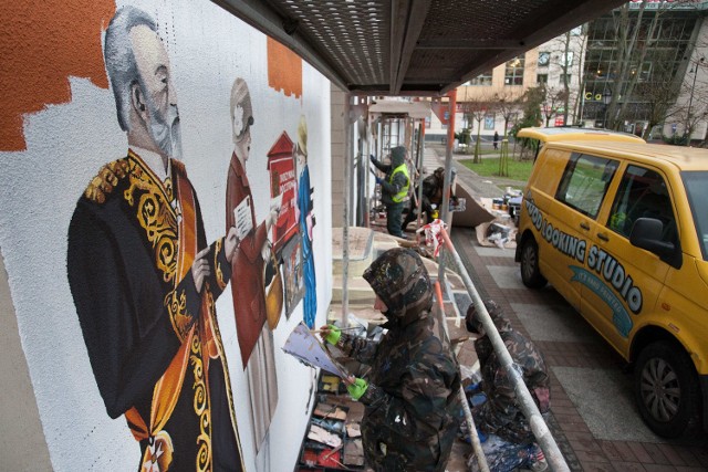 Na ścianie budynku przy skwerze Pierwszych Słupszczan powstaje kolejny mural. Przedstawiał będzie scenkę rodzajową z życia miasta. Zobaczymy na nim również artystów i twórców związanych ze Słupskiem. Otwarcie murala planowane jest w pierwszej połowie grudnia. Towarzyszył mu będzie happening w wykonaniu młodzieży artystycznej teatru Rondo. W ciągu ostatnich miesięcy w centrum miasta powstały już cztery murale. Oglądaj także: "Wiatr od morza" - nowy mural w Słupsku