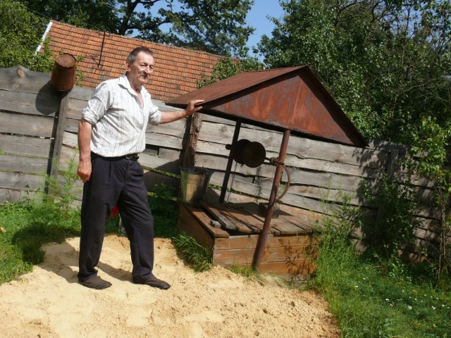 Jerzy Michałowicz przy studni, w której woda zatruta jest bakteriami Coli.