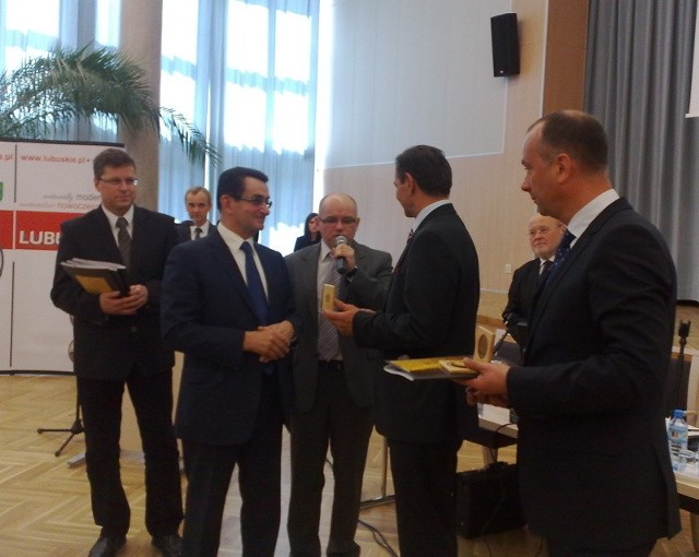 Prezydent Gerard Miguel wręcza odznakę honorową za współpracę przewodniczącemu sejmiku Krzysztofowi Sewerynowi Szymańskiemu