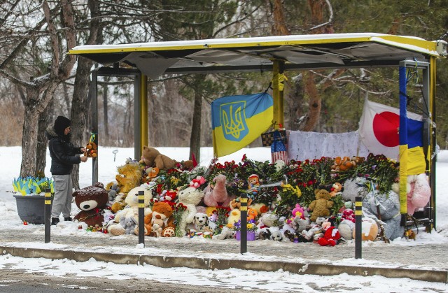 W rocznicę ataku na blok mieszkalny Ukraińcy składają hołd i kwiaty na przystanku autobusowym. Tu obok w wyniku ataku rakietowego 14 stycznia 2023 r. w Dnieprze zginęło 46 osób, w tym kilkoro dzieci