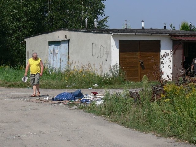Właściciel garażu Krzysztof Ziętek z oburzeniem pokazuje resztki wokół wywiezionego kontenera.