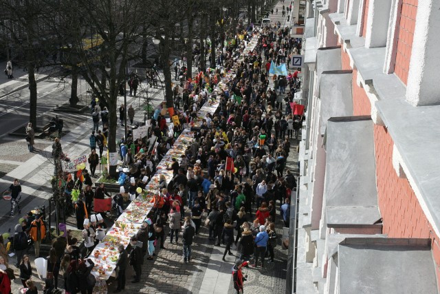 Uczniowie z kolorowymi transparentami zachęcali do zdrowego odżywiania się.