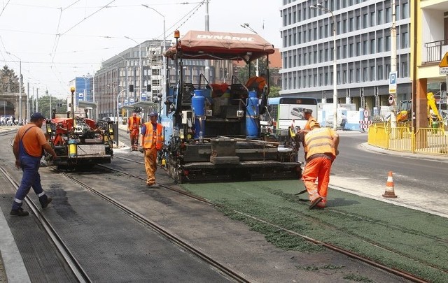 Wylewanie zielonego asfaltu. Po modernizacji autobusy pojadą po szynach, stąd ten wyznaczony,m kolorowy tor.