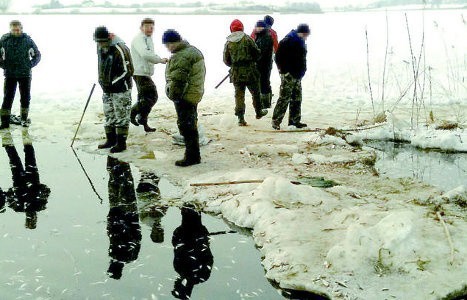 Grupę kłusowników uzbrojonych w osęki ("kije&#8221; do podbierania ryb) oraz biernie się temu przyglądających mężczyzn na Jeziorze Łasin Duże sfotografował jeden z wędkarzy