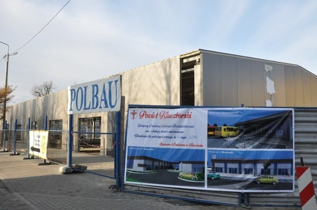 Nowy dworzec PKS w Kluczborku w budowie. Na ogrodzeniu wisi baner z wizualizacjami obiektu.