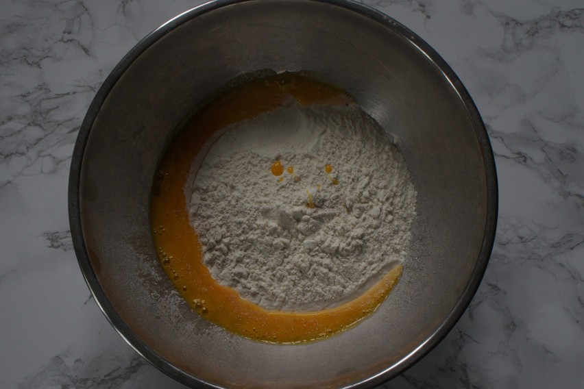 Rozkłócone jajko należy wlać do mąki pszennej z drożdżami.