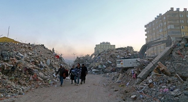 Miejscowi ludzie w pobliżu miejsca zawalenia się budynków po potężnym trzęsieniu ziemi w Kahramanmaras w Turcji