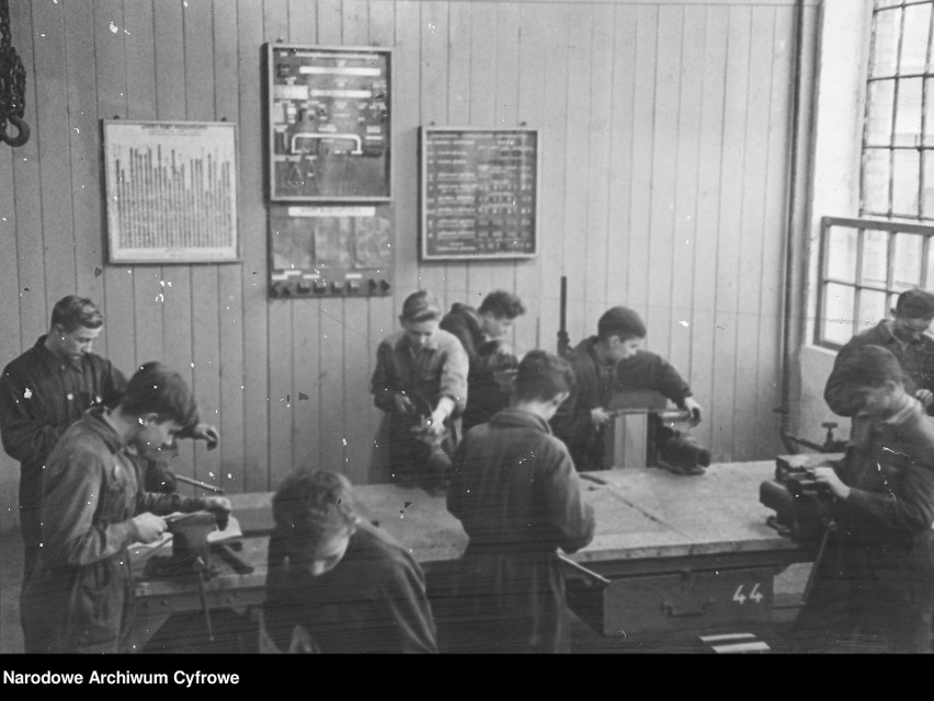 Uczniowie przy imadłach w szkolnych warsztatach.