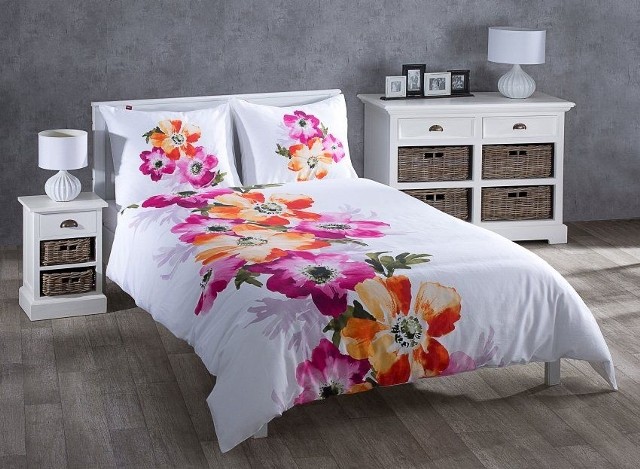 Motyw kwiatowy na pościeliPościel z kolorowymi kwiatami nadaje charakteru w sypialni urządzonej w spokojnych barwach.