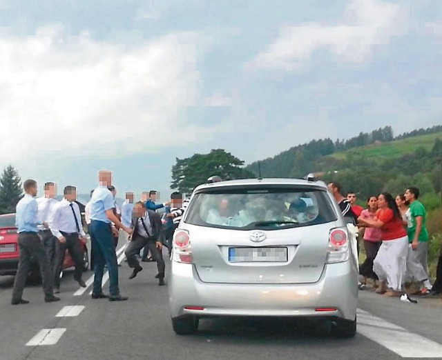 Bójka przy bramie weselnej. Po lewej goście weselni, po prawej Romowie