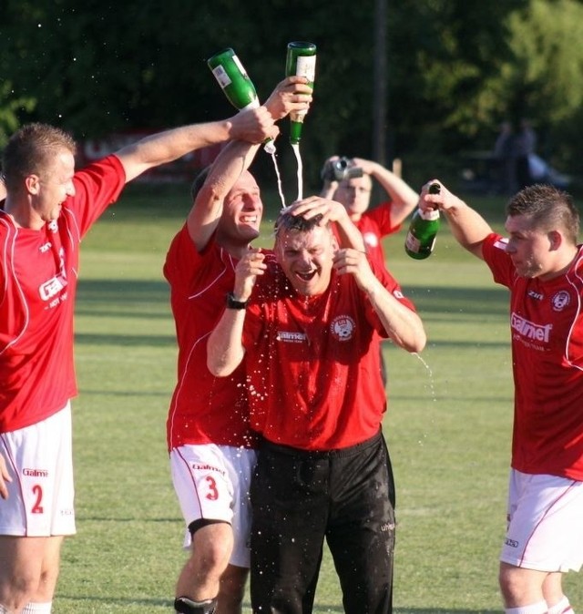 Trener Malek Malewicz (w środku) i jego piłkarze otworzyli szampany.