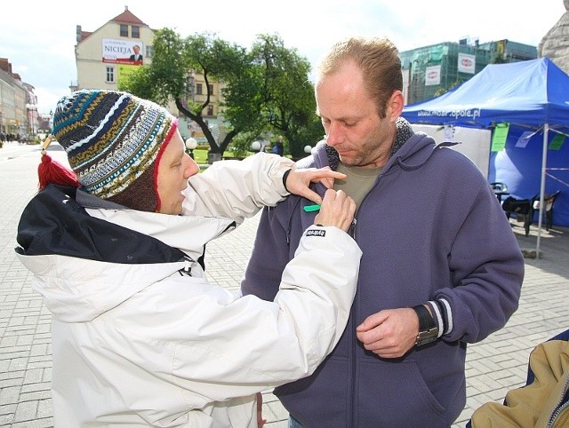 Brygida Widera, prezes Milenium przypina wstążkę Robertowi Piłce.