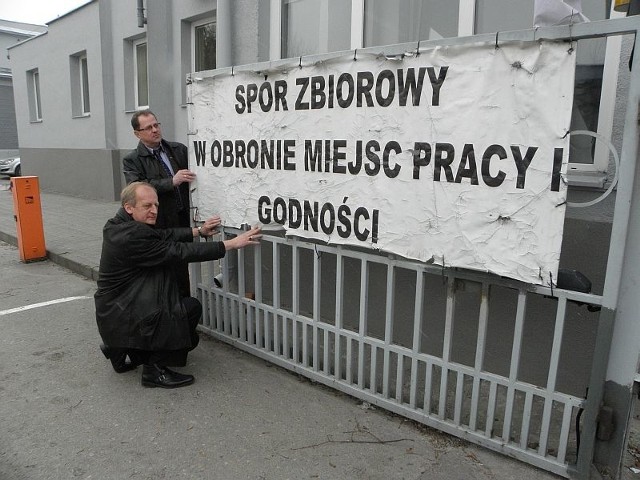 Związkowcy Jerzy Gawęda i Krzysztof Kaszak przy banerze, który wisi na bramie Solino
