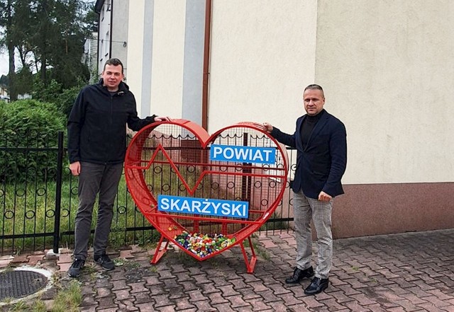 Członek zarządu powiatu skarżyskiego Adam Ciok i starosta Artur Berus przy nowym "sercu na nakrętki" na osiedlu Bór w Skarżysku.