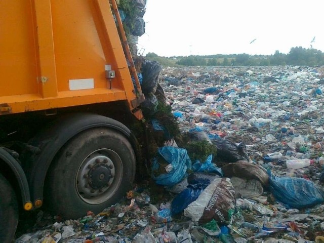 Worki z odpadami zielonymi wyrzucane na składowisko