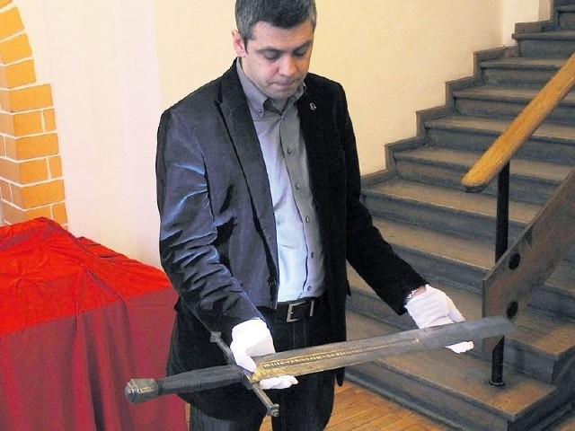 Dyrektor Muzeum w Stargardzie, Marcin Majewski prezentuje miecz katowski.