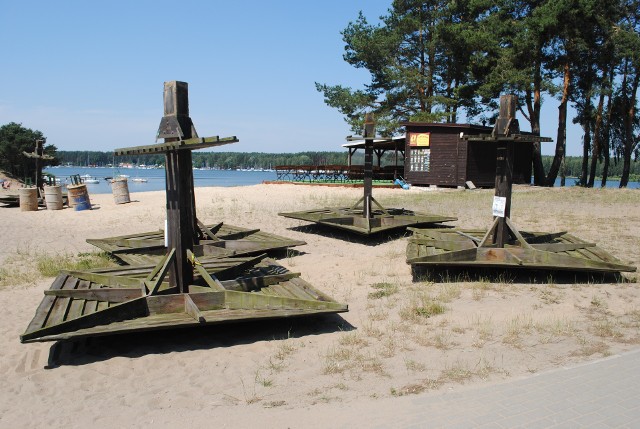 Głos z Pieczysk :- Przyjedź  pan i  zobacz,  jak wycinają  drewniane parasole! Teraz to już mamy zupełnie łysą plażę...  Pojechałem,  zobaczyłem. Na plaży ciągnik, ekipa z gminy Koronowo zdążyła już zdemontować wszystkie - było ich osiem - drewniane  parasole, które od lat zdobiły plażę w Pieczyskach. - Niestety, ich stan techniczny był  taki, że trzeba je było zdemontować. Będą nowe, metalowe, ale nie zdążymy zamontować  w tym sezonie  - mówi Maciej Makowski, dyrektor Ośrodka Sportu i Rekreacji w Koronowie, zawiadujący także kąpieliskiem w Pieczyskach. Pisaliśmy już - nie będzie w tym roku pomostów, bo nie ma na to zgody Wód Polskich, nie będzie też wczoraj zdemontowanych parasoli... Pieczyska - stolica Zalewu Koronowskiego marnieje...