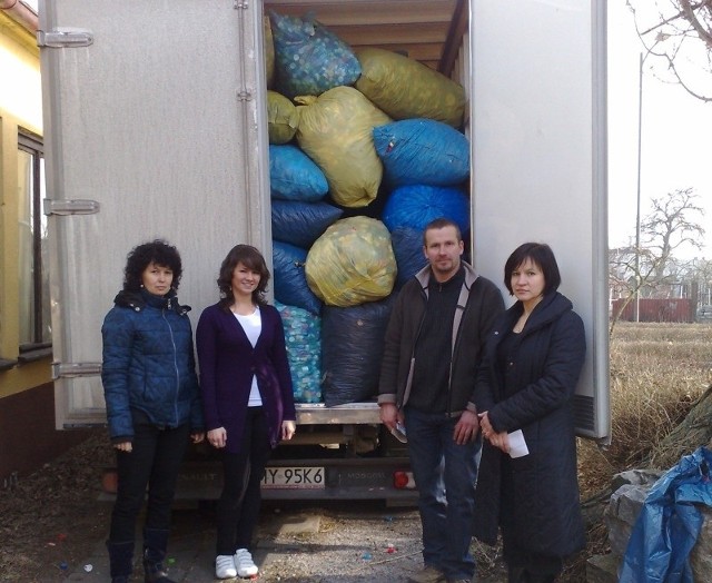 Od lewej: Monika Nowak, Klaudia Paprotny, Katarzyna Kleszcz z pracownikiem firmy recyklingowej, który przyjechał po nakrętki.