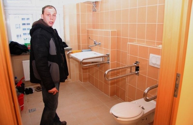 Przemysław Wójcicki, kierownik robót w budynku przy ulicy Szkolnej, pokazuje łazienki, które są przystosowane dla potrzeb uczniów szkoły specjalnej.