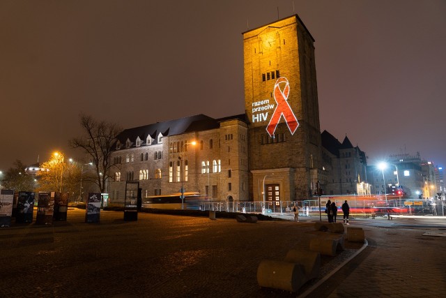 Z okazji zbliżającego się Światowego Dnia HIV, w środę na poznańskich budynkach wyświetlono czerwone kokardki.
